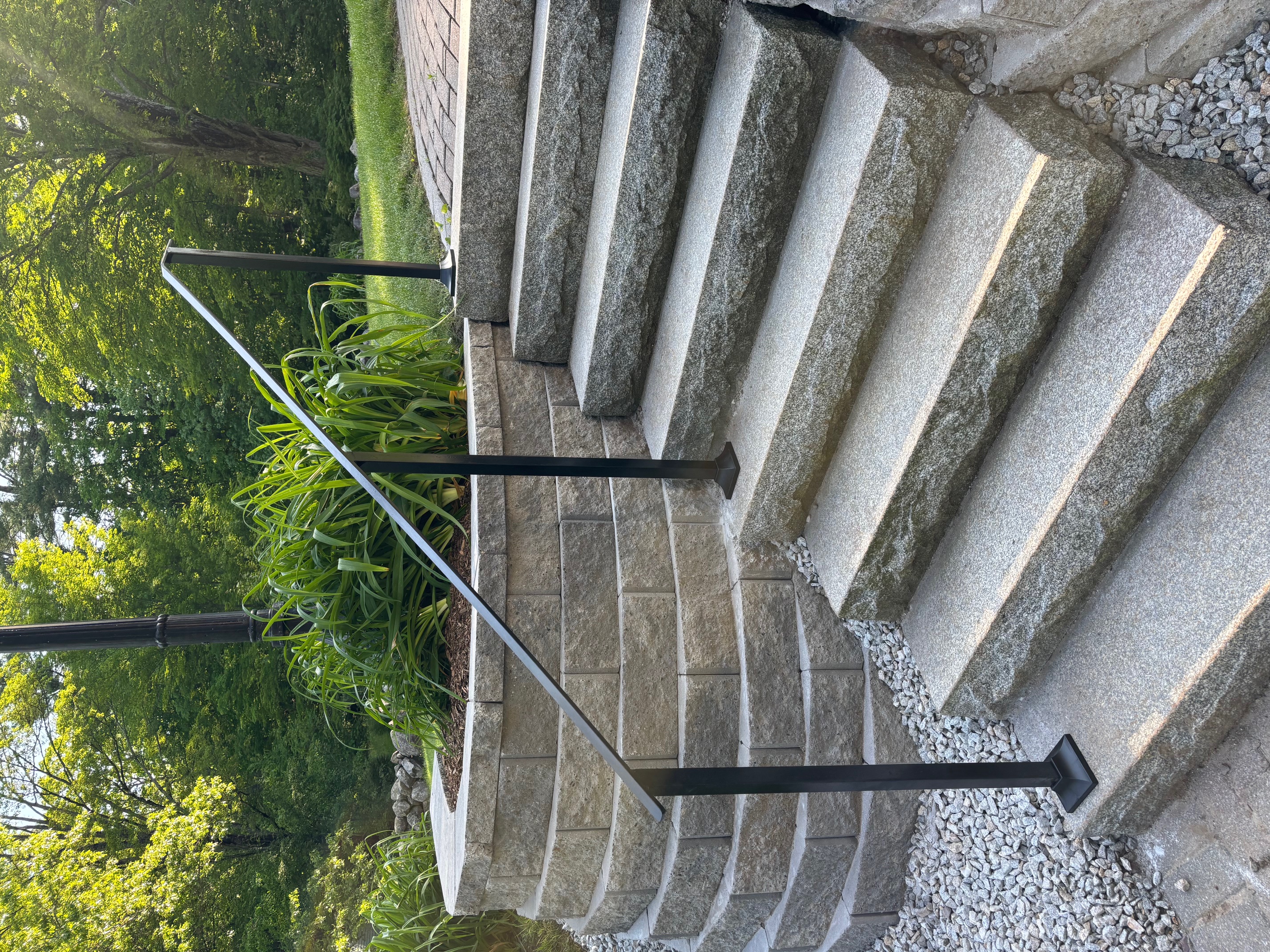 Custom welded steel handrail on curved granite steps in New England